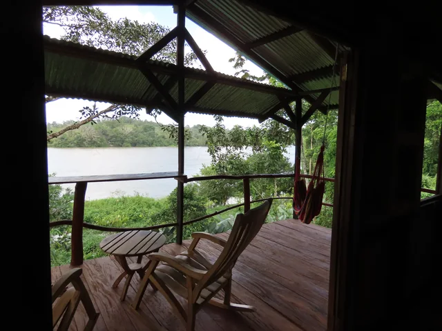 Terraza de cabaña con vista al río San Juan y mecedoras de madera en La Mariola.